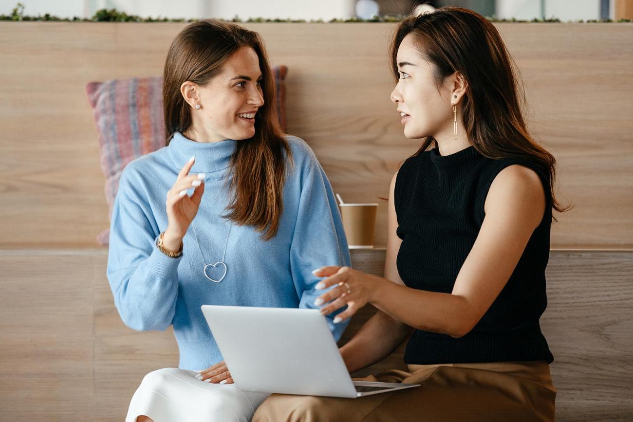 Two business women sitting in front of laptop