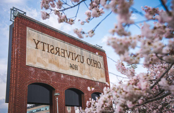 A photo of the Ohio University sign with cherry blossoms